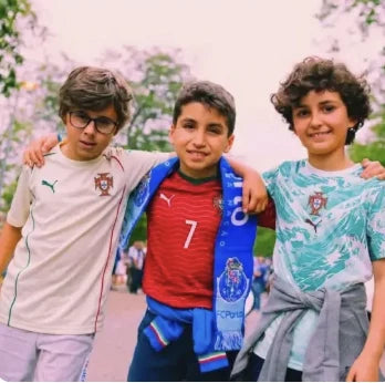 Três miúdos com camisolas de futebol
